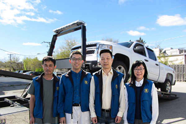 Car donation staff stand in front of the tow truck